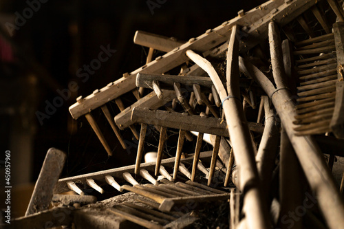 Close-up of old rakes in a rustic work shop