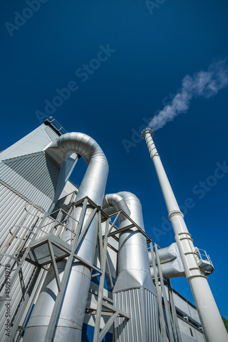 Biofuel boiler chimneys on a blue sky background. Electrostatic precipitator in the foreground 