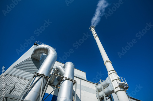 Biofuel boiler chimneys on a blue sky background. Electrostatic precipitator in the foreground 