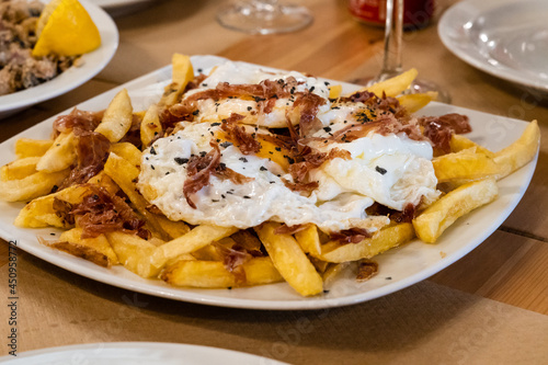 Typical Spanish food, fried eggs, chips and ham. Scrambled eggs