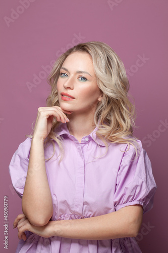 Smiling young beautiful blonde woman wearing pink dress