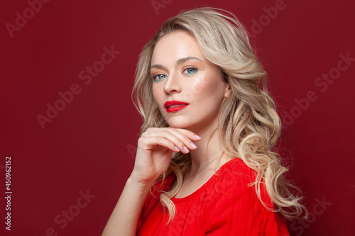 Beauty portrait of cute blond female face with natural skin on red