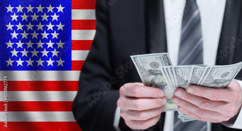 Dollars banknotes in male hands on National USA flag background © artmim