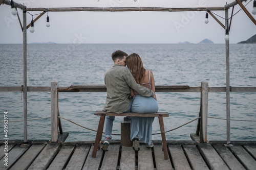 Lovely young couple enjoying honeymoon by the sea. Foreheads touch. Wearing casual clothes. High quality photo