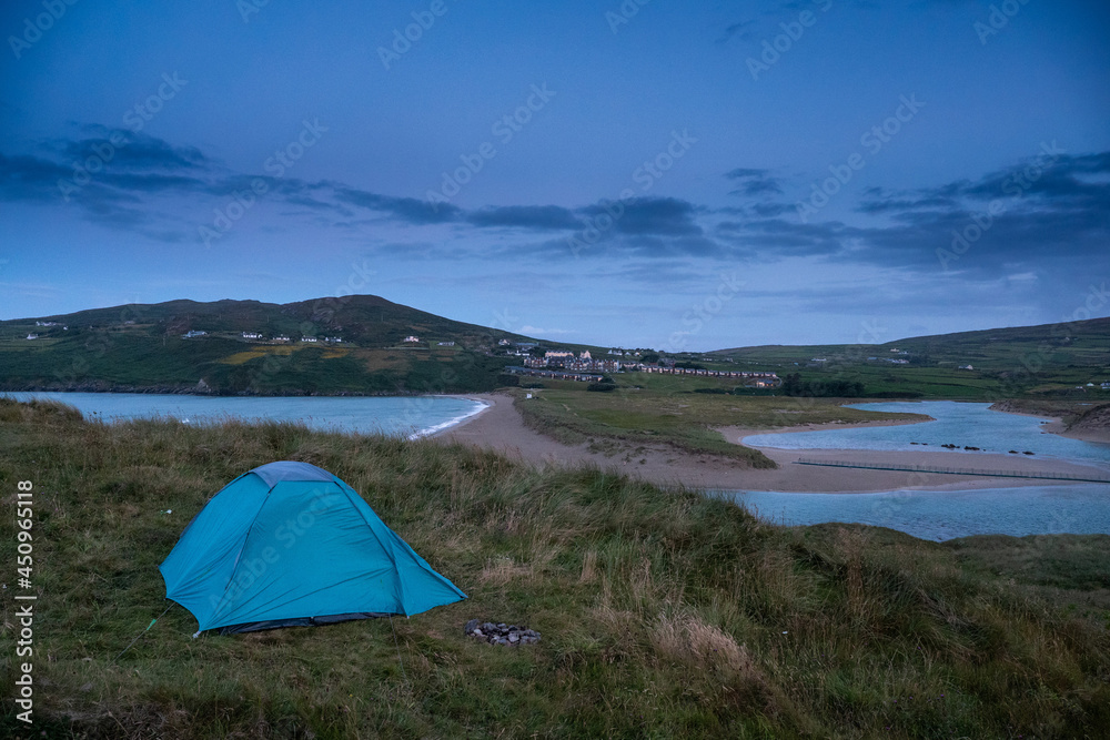 Night scene. Blue tent on a grass. Barleycove beach in the background