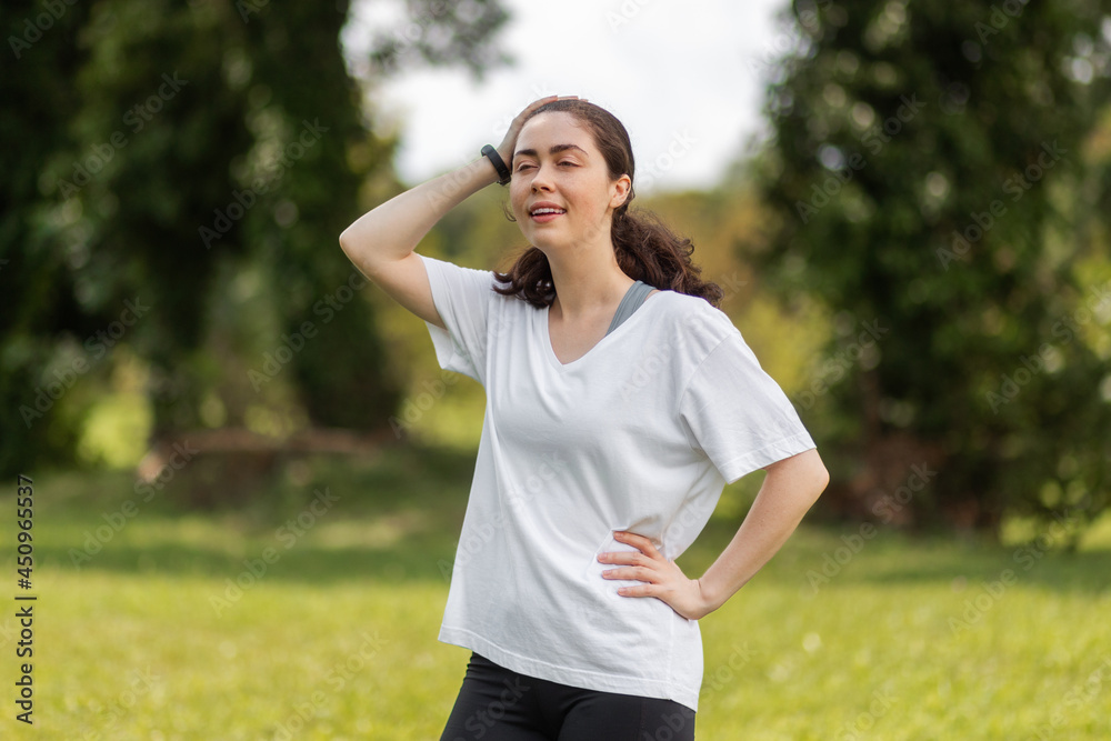 Young woman with smart watch on hands relax after warmup at the park. The concept of a modern device and wellness Young woman with smart watch on hands relax after warmup at the park. The concept of a modern device and wellness