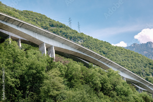 Highway Bridge Country Road Over The Mountain, Roadway Overpass Structure Building With Mountains Background. Country Freeway Along Europe Alps at Switzerland. Elevated Road for Vehicle Transportation