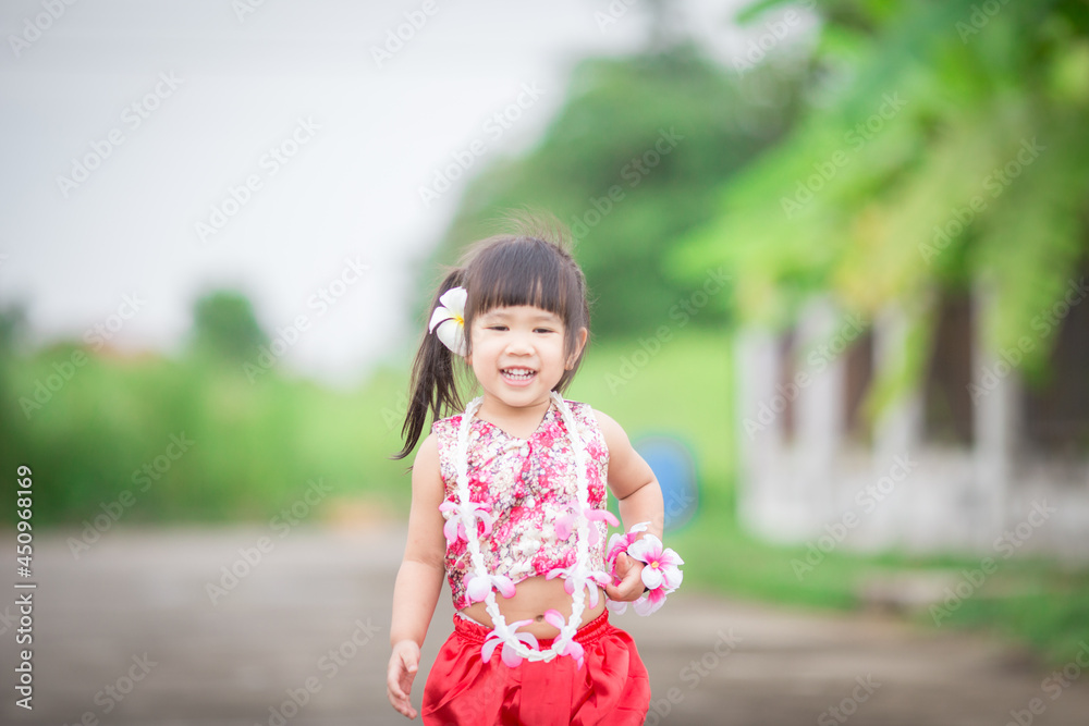 Close-up background view of a blurred Asian girl running or teasing in the street in front of the house, doing activities together outside the classroom during the holidays. Close-up background view of a blurred Asian girl running or teasing in the street in front of the house, doing activities together outside the classroom during the holidays.