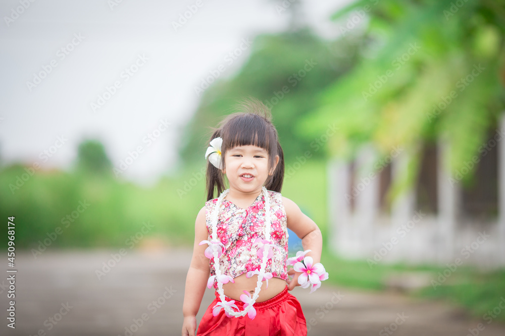 Close-up background view of a blurred Asian girl running or teasing in the street in front of the house, doing activities together outside the classroom during the holidays. Close-up background view of a blurred Asian girl running or teasing in the street in front of the house, doing activities together outside the classroom during the holidays.