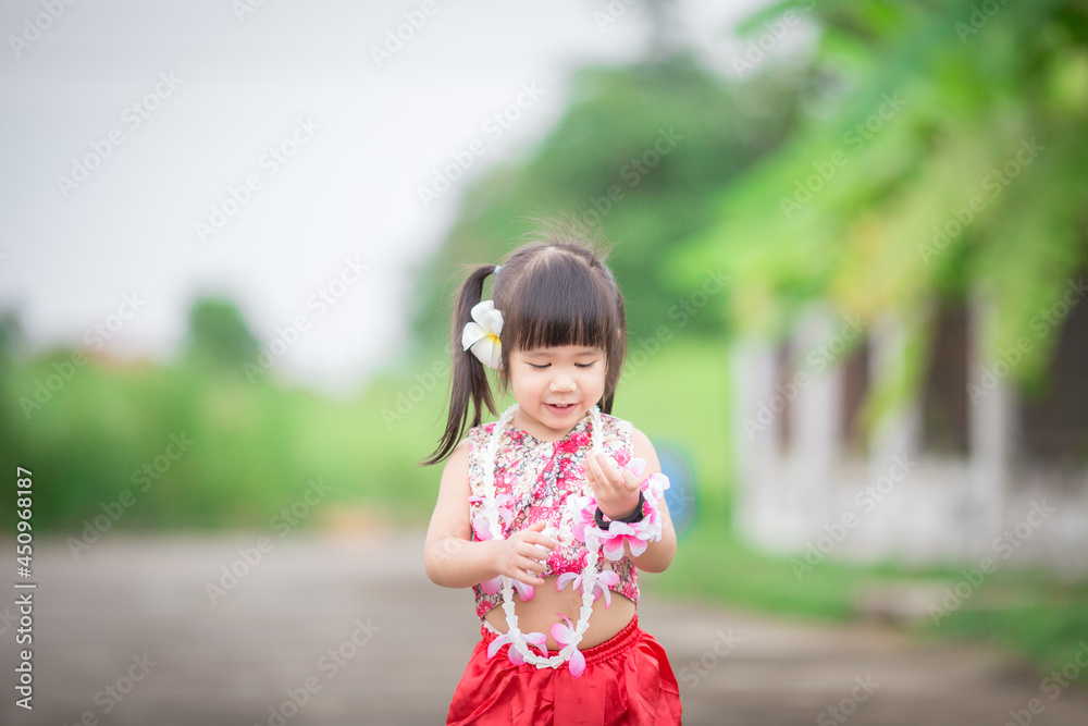 Close-up background view of a blurred Asian girl running or teasing in the street in front of the house, doing activities together outside the classroom during the holidays. Close-up background view of a blurred Asian girl running or teasing in the street in front of the house, doing activities together outside the classroom during the holidays.