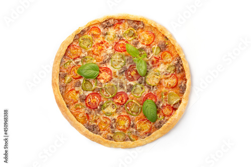 Italian meat pizza with tomatoes, three types of meat (sausages, bacon, minced meat), mozzarella cheese decorated with green basil leaves.