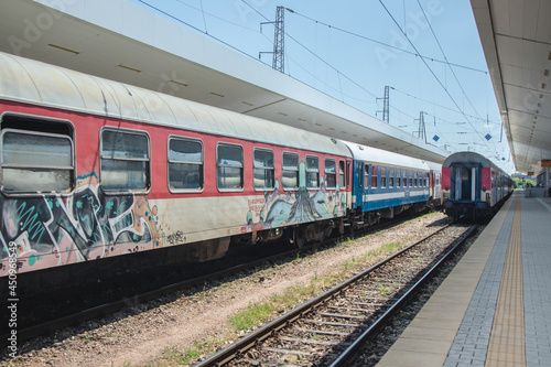 Passenger train with graffiti at the train station in the city. Railway station