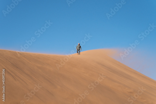 Positive attitude towards life. People walking on the sand dunes. Namibia, Africa.