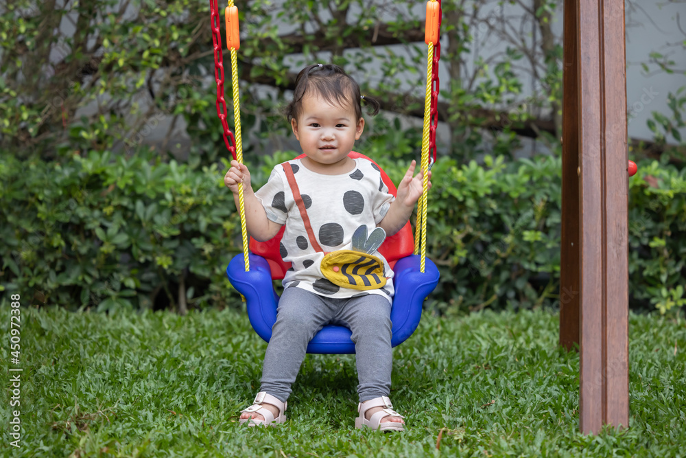 Asian Baby Have Fun Playing on a Kid Swing in the Playground Asian Baby Have Fun Playing on a Kid Swing in the Playground