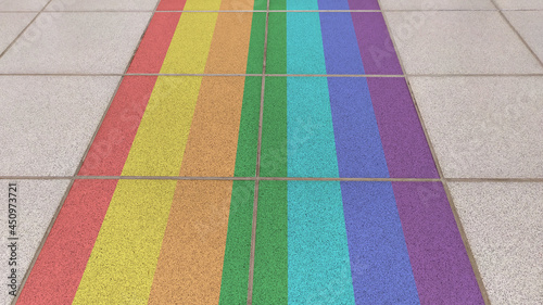 Rainbow on the pavement. A rainbow pattern is drawn on the sidewalk in a city park.
