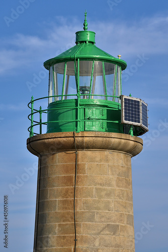 Beautiful closeup vertial evening view of green West Pier lighthouse in Dun Laoghaire harbor, Dublin, Ireland. Top of lighthouse tower. Soft and selective focus