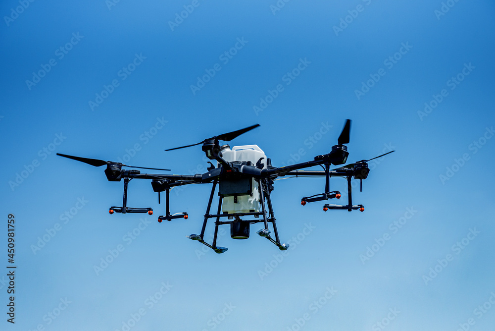 Professional agriculture drone flying in the blue sky Professional agriculture drone flying in the blue sky