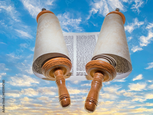 Fototapeta Opened Torah scrolls on the background of the sunset against the blue sky