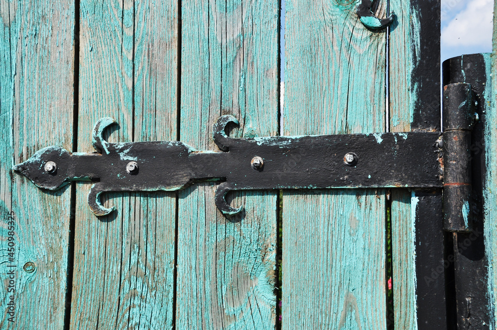 Forged metal hinges of an old wooden door. Background, texture, design. Forged metal hinges of an old wooden door. Background, texture, design.
