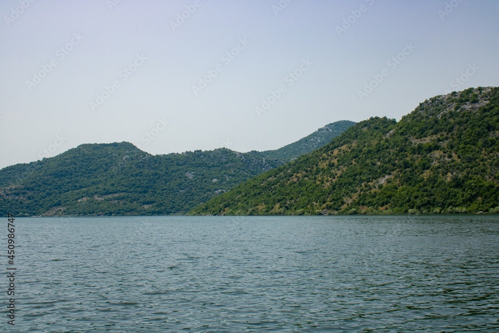 Croup of mountains around beautiful lake. Landscape on the natural park highlands. Panoramic view on the lakeshore.