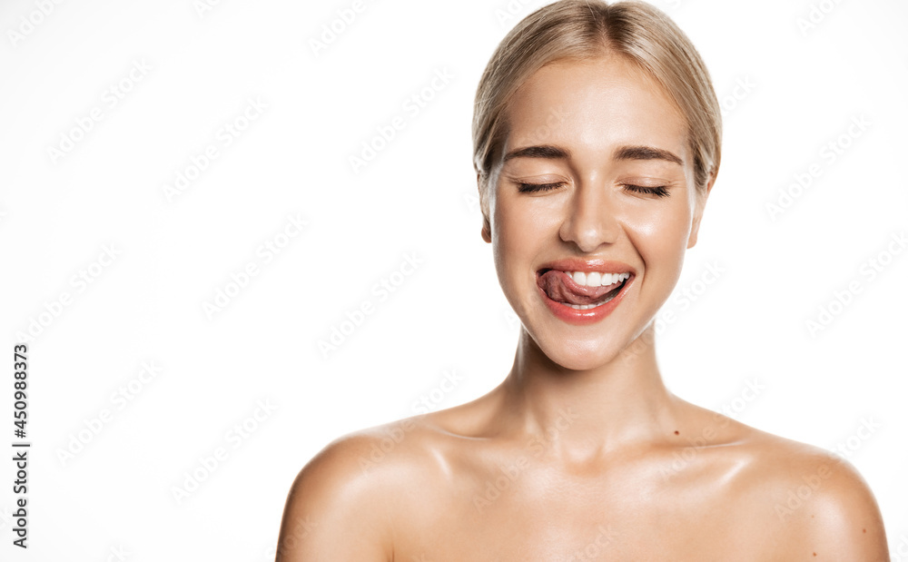 Happy blond woman, smiling with tongue, showing white perfect teeth smile, close eyes thoughtful, portrait of head and shoulders after shower effect, isolated against studio background Happy blond woman, smiling with tongue, showing white perfect teeth smile, close eyes thoughtful, portrait of head and shoulders after shower effect, isolated against studio background