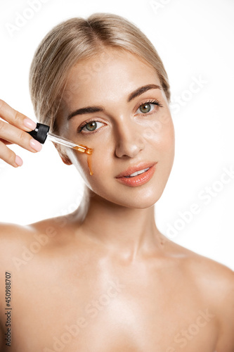 Beauty and skin care concept. Face of woman applying tea tree and lemon facial C-Serum, using anti-aging treatment products, hydrating and nourishing skin for better tone