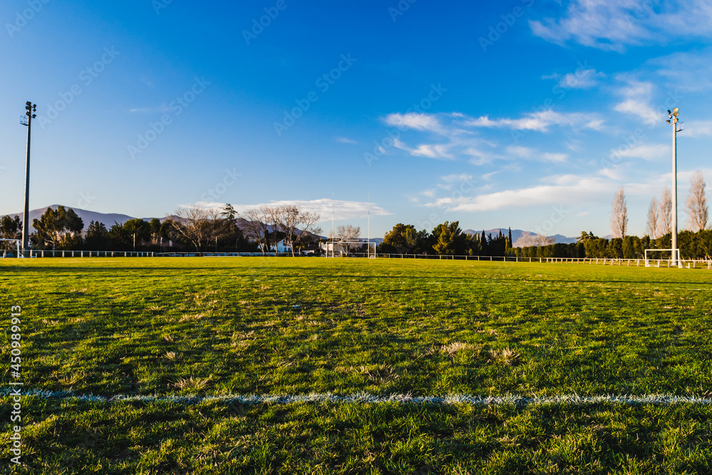 Green football field with blue sky