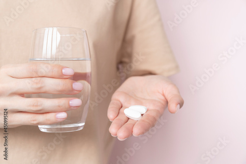 Photography Woman holding pill and glass of water in hands taking emergency medicine, supple