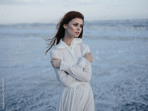 pretty woman in white dress by the ocean posing vacation