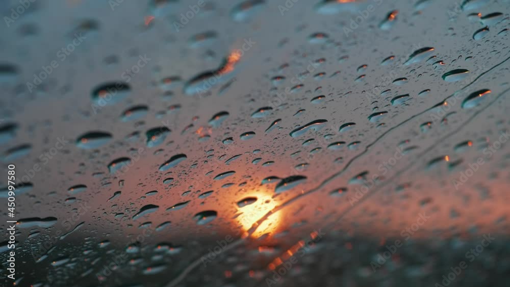 travel by car concept, beautiful sunset view thrrough window glass, summer adventures outdoor. close up of water droplets on glass. rain drops background