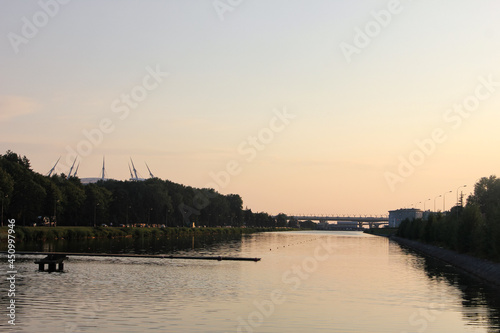 Petersburg, Krestovsky Island. July 15, 2021. Grebnoy channel for training rowers. Evening, sunset. Gazprom Arena and the Tyukalov School of Higher Sports Skills in water sports are visible photo