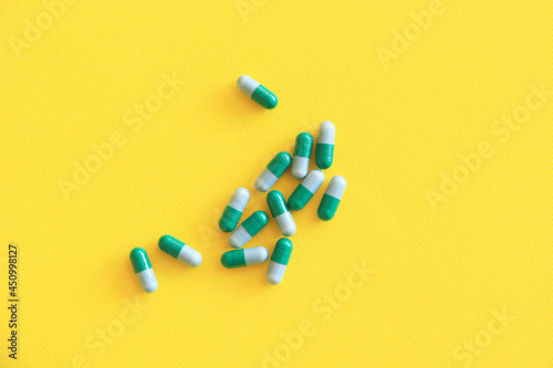 Colorful pills on yellow background