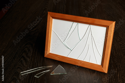 Broken glass in a photo frame. A shard on the table