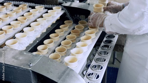 worker put waffle ice cream cups to filling conveyor photo