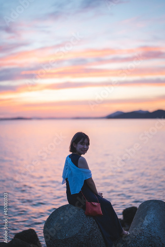 夕暮れの海の女性