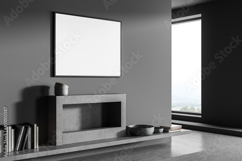 Horizontal poster on grey living room wall with fireplace. Corner view.