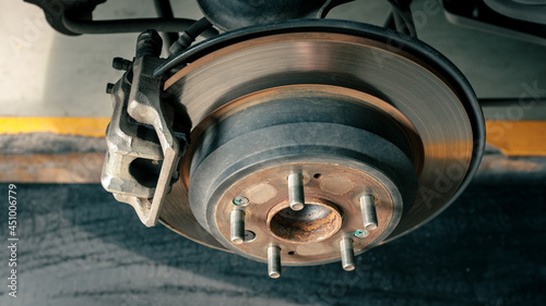 detail of car disc brake to be fixed at garage or automotive service station, process of tire replacement