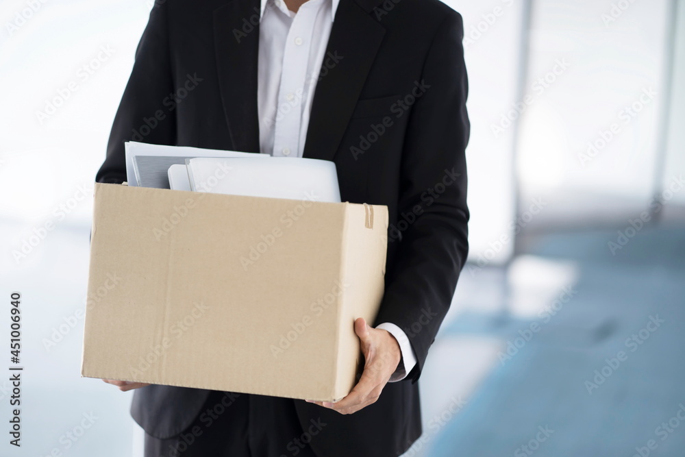 Fired businessman carrying box of personal items Fired businessman carrying box of personal items
