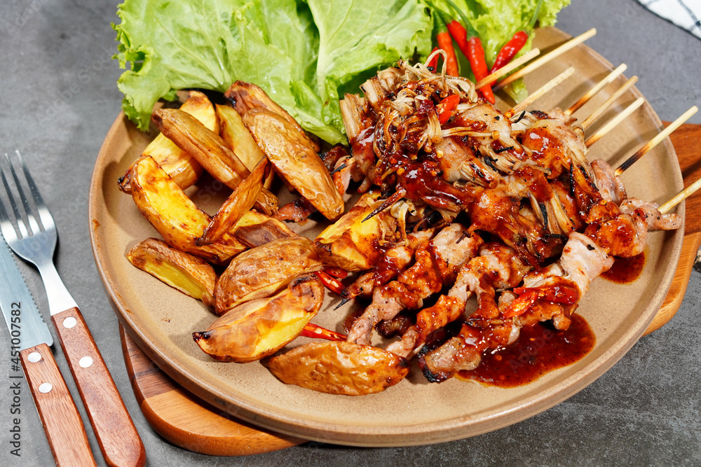 Barbecue or mala pork and mushrooms, bacon in a plate on a wooden cutting board Barbecue or mala pork and mushrooms, bacon in a plate on a wooden cutting board