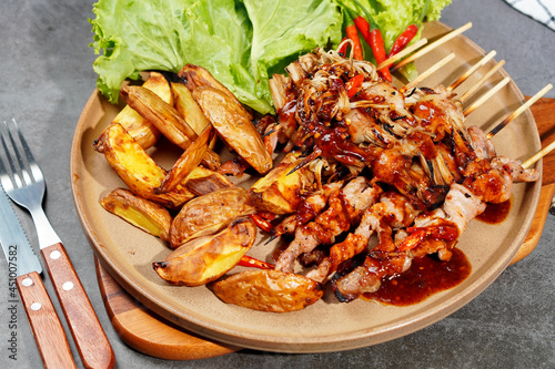 Barbecue or mala pork and mushrooms, bacon in a plate on a wooden cutting board