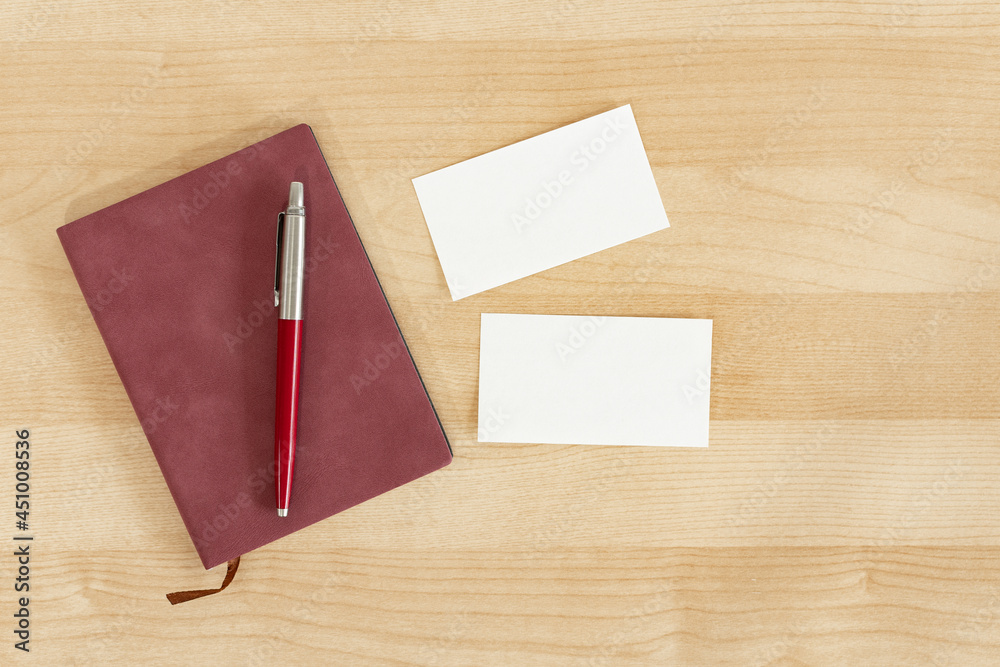 Blank business cards, burgundy notebook and pencil on wooden office table. Business card Mock Up. Blank business cards, burgundy notebook and pencil on wooden office table. Business card Mock Up.