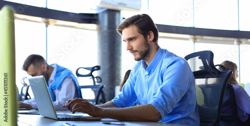 Modern business men analyzing stock market data while working in the office.