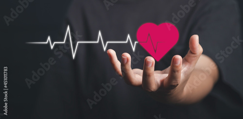 Health care, organ donation, life insurance, world heart day, world health day concept. Hand holding red heart with heartbeat line or cardiogram.