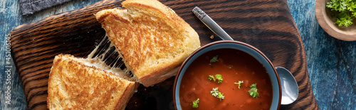 Canvas Print Top down view of a grilled cheese sandwich served with a bowl of tomato soup, ready for eating