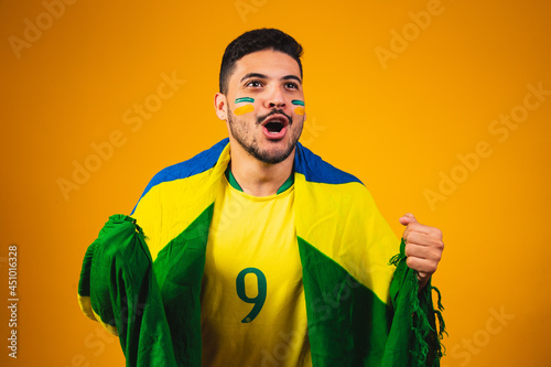 brazilian fan cheering in the crowd on yellow background. photo