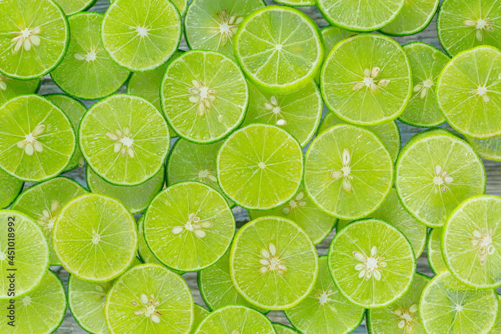 Macro Lime,Fresh lime slices as a background,Lemon and green lime overlapped slices close-up background. Macro Lime,Fresh lime slices as a background,Lemon and green lime overlapped slices close-up background.