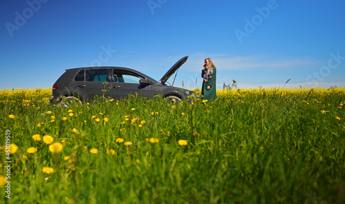 Woman near broken car calling for help.