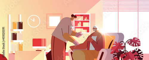 doctor in mask vaccinating old patient practitioner giving injection to senior woman fight against coronavirus vaccination