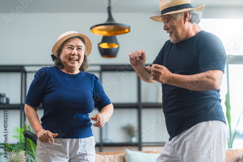 Fototapeta Naklejka Na Ścianę i Meble -  asian senior happiness couple home isolation concept,asian old retired adult couple dancing together at living room with cheerful and joyful moment ,Lovely senior couple dancing at home