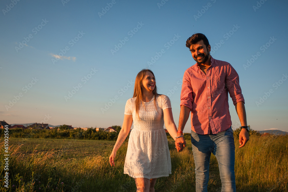 Lovely couple walking in the summer field Lovely couple walking in the summer field